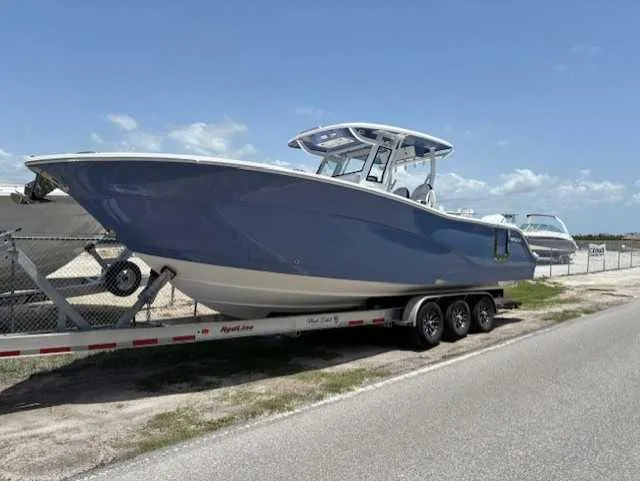 Black Label Marine Yacht Photos Pics 2025 Sea Fox 328 Commander boat on trailer, parked roadside under clear sky.