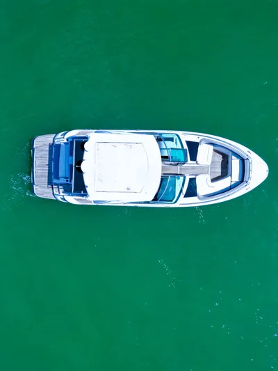 Yacht Photos Pics Aerial view of 2017 Four Winns H350 boat on vibrant green water.