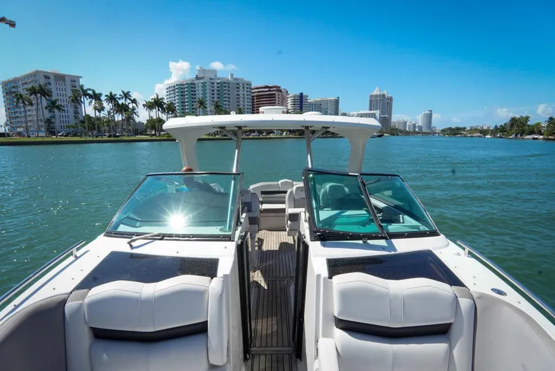  Yacht Photos Pics 2017 Four Winns H350 boat cruising on a sunny day with city skyline backdrop.