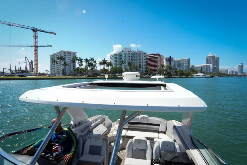  Yacht Photos Pics 2017 Four Winns H350 boat cruising near city skyline and construction cranes.