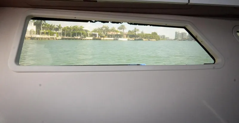  Yacht Photos Pics View from Four Winns H350 boat window, overlooking serene waterfront and distant buildings.