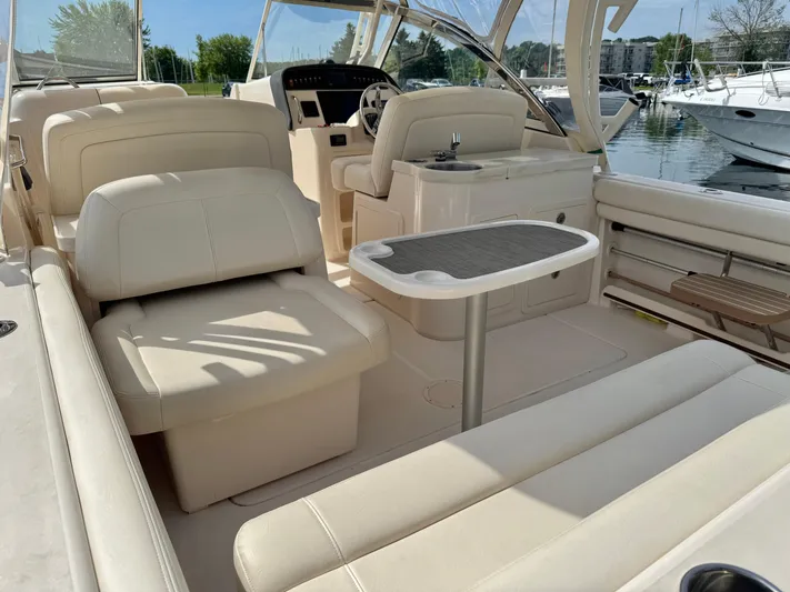 Bay Tripper Yacht Photos Pics 2019 Grady-White Freedom 307 boat interior with beige seating and table, docked at marina.