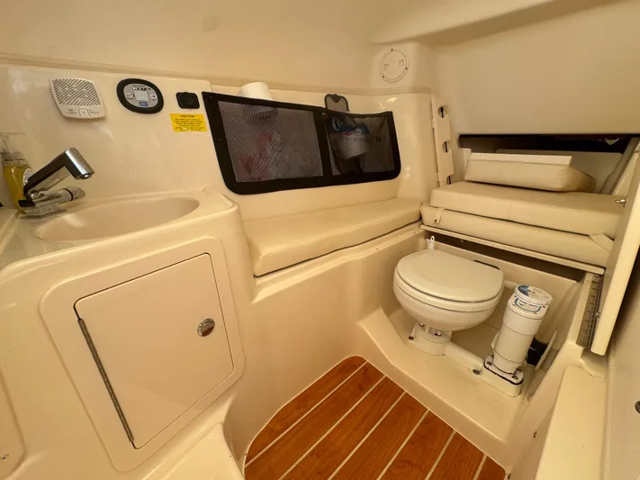 Bay Tripper Yacht Photos Pics 2019 Grady-White Freedom 307 boat interior with sink, toilet, and wooden flooring.