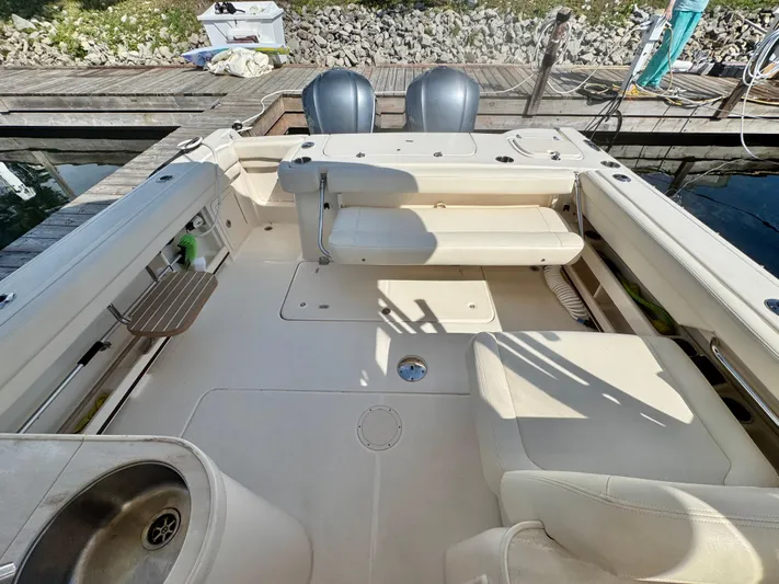 Bay Tripper Yacht Photos Pics 2019 Grady-White Freedom 307 boat interior with seating and sink, docked by the water.