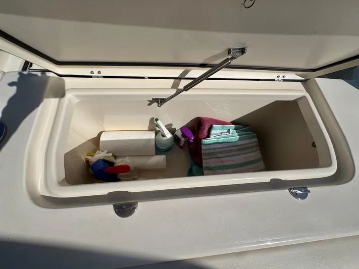 Bay Tripper Yacht Photos Pics Open storage compartment on 2019 Grady-White Freedom 307 boat with cleaning supplies and towels.