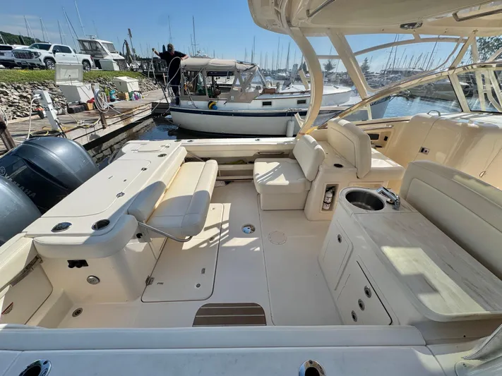 Bay Tripper Yacht Photos Pics 2019 Grady-White Freedom 307 boat interior with seating and sink, docked at marina.