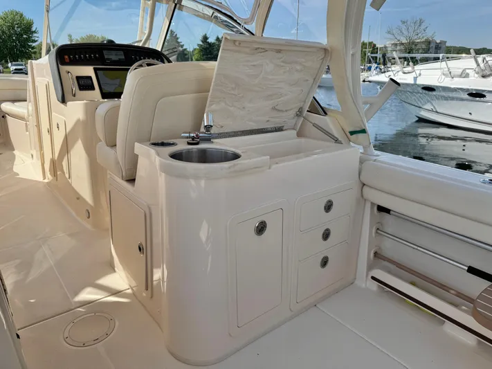 Bay Tripper Yacht Photos Pics 2019 Grady-White Freedom 307 boat interior with helm, sink, and storage drawers.