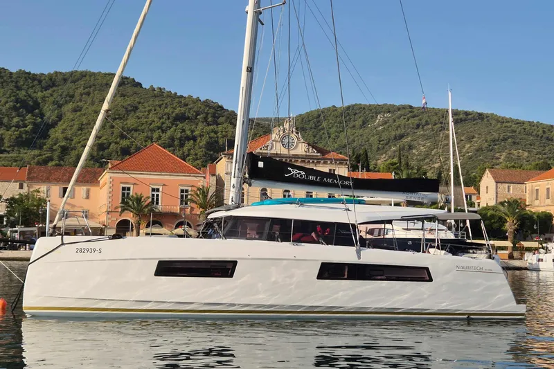 Double Memory Yacht Photos Pics 2023 Nautitech 44 Open catamaran docked in scenic harbor with lush hills.
