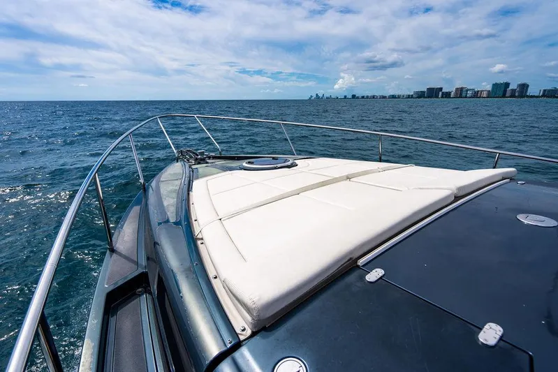 Two Bite Yacht Photos Pics 2018 Pershing 5x yacht cruising on open sea with city skyline in background.