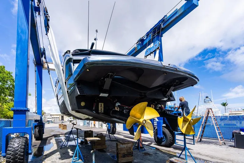 Two Bite Yacht Photos Pics 2018 Pershing 5x yacht in dry dock with visible propellers and maintenance equipment.