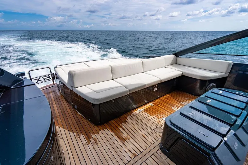 Two Bite Yacht Photos Pics Luxurious 2018 Pershing 5x yacht deck with white seating, cruising on open sea.