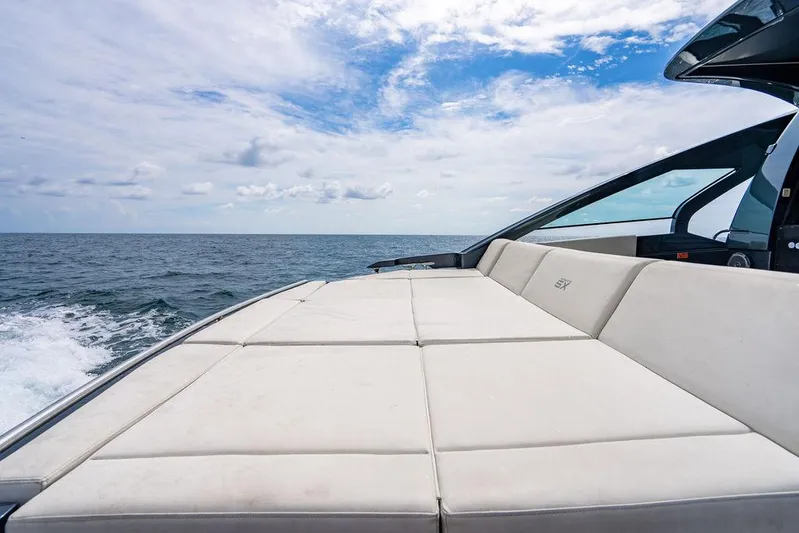 Two Bite Yacht Photos Pics Luxurious 2018 Pershing 5x yacht with spacious sun deck, cruising on open sea under blue sky.