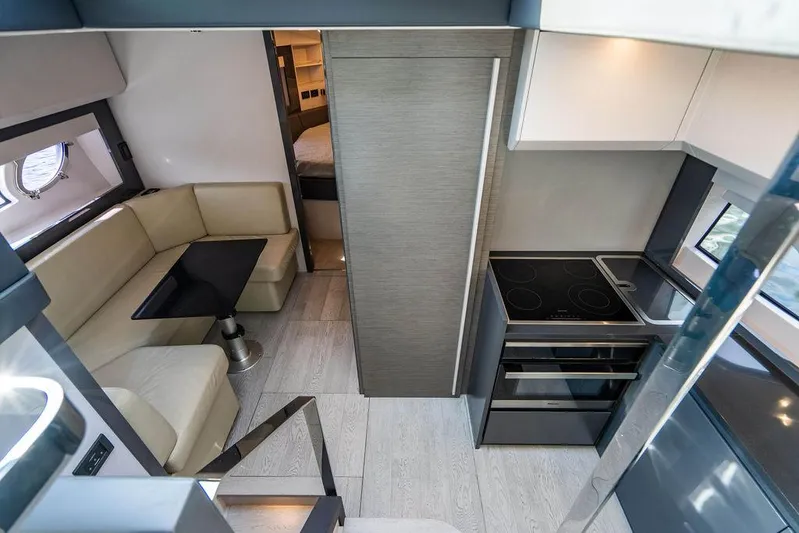 Two Bite Yacht Photos Pics Interior of 2018 Pershing 5x yacht featuring modern kitchen and cozy seating area.