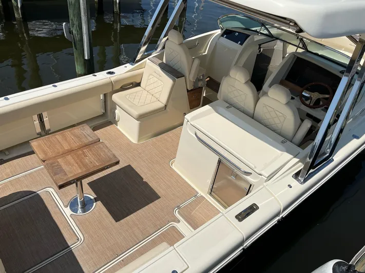  Yacht Photos Pics 2019 Chris-Craft Calypso 30 boat interior with seating and wooden tables.
