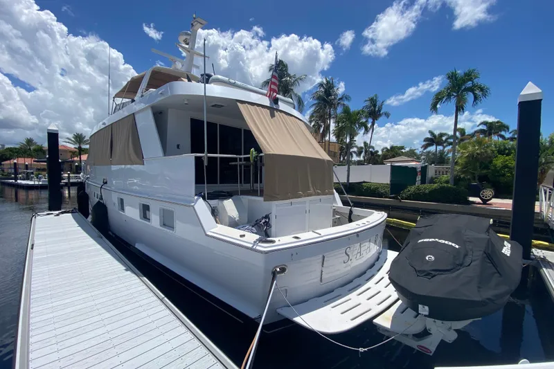  Yacht Photos Pics 1991 Hatteras 70 Motor Yacht docked under a sunny sky with palm trees.