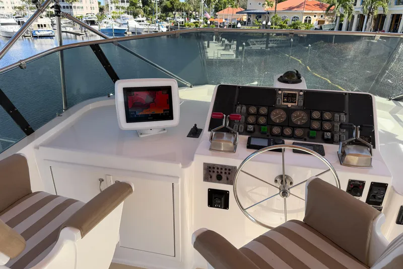  Yacht Photos Pics 1991 Hatteras 70 Motor Yacht helm with navigation equipment and striped seating.