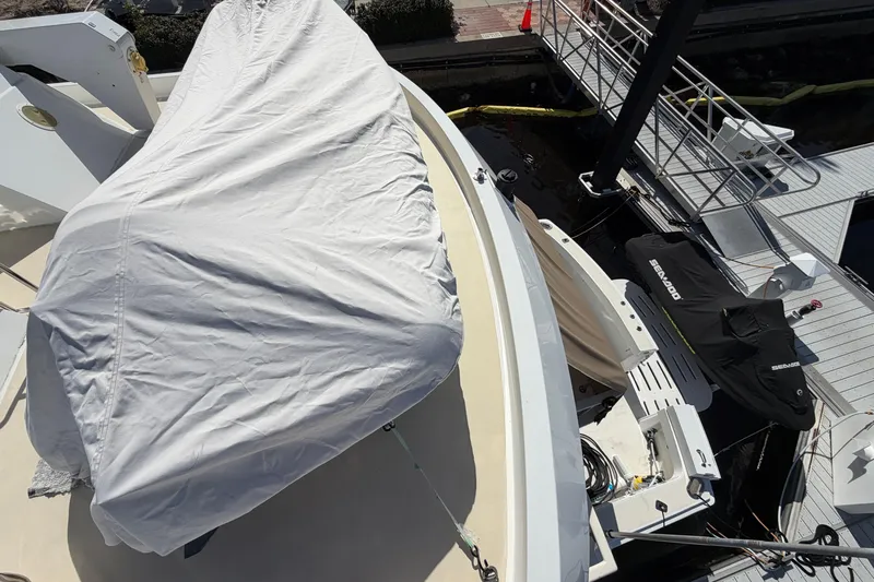  Yacht Photos Pics 1991 Hatteras 70 Motor Yacht deck with covered equipment and docked jet ski.