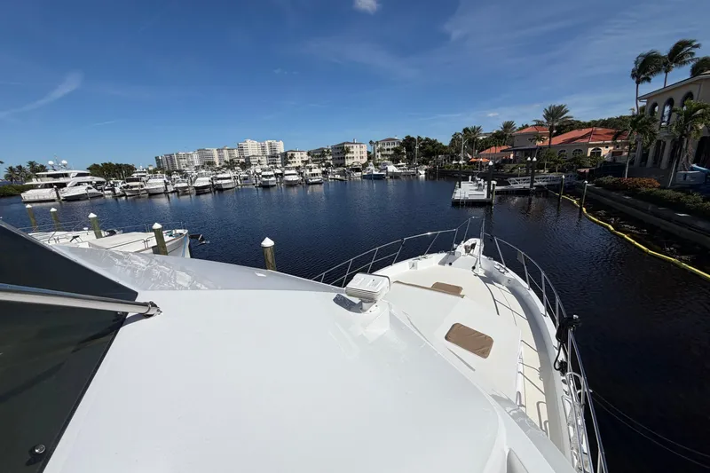 Yacht Photos Pics 1991 Hatteras 70 Motor Yacht docked in a scenic marina with clear skies.