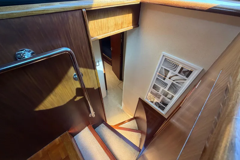  Yacht Photos Pics Interior staircase of 1991 Hatteras 70 Motor Yacht with wooden finish and modern decor.