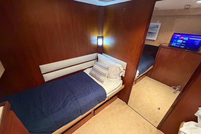  Yacht Photos Pics 1991 Hatteras 70 Motor Yacht cabin with cozy bed and modern TV setup.