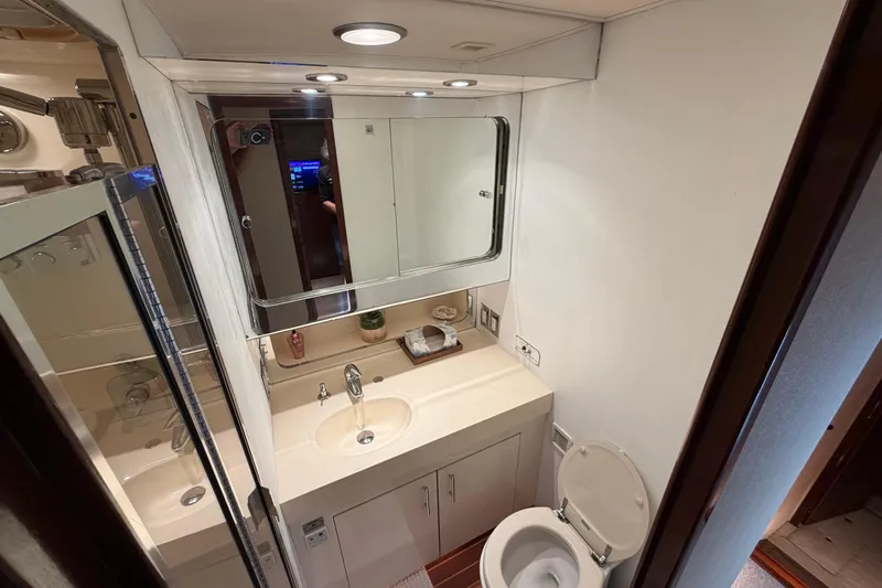  Yacht Photos Pics Bathroom interior of 1991 Hatteras 70 Motor Yacht with sink, mirror, and toilet.