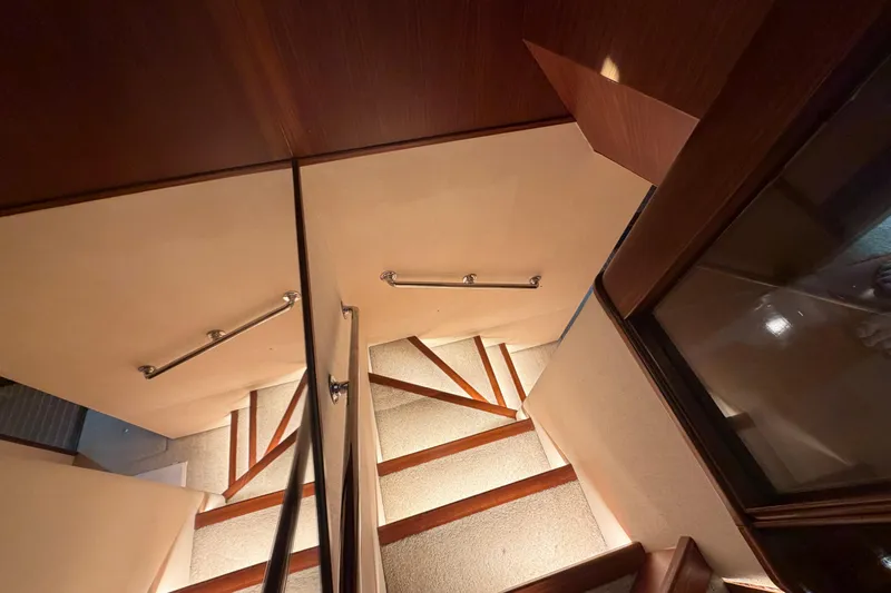  Yacht Photos Pics Staircase inside 1991 Hatteras 70 Motor Yacht with wooden accents and handrails.