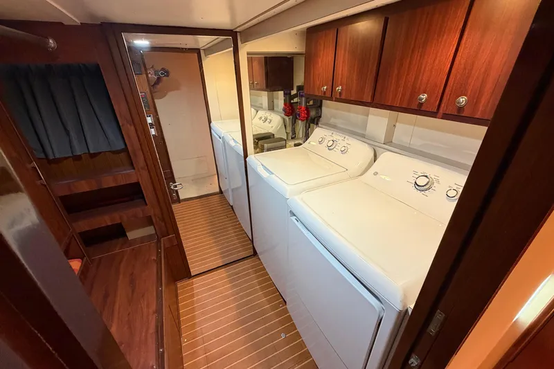  Yacht Photos Pics Laundry area in 1991 Hatteras 70 Motor Yacht with washer, dryer, and wooden cabinetry.