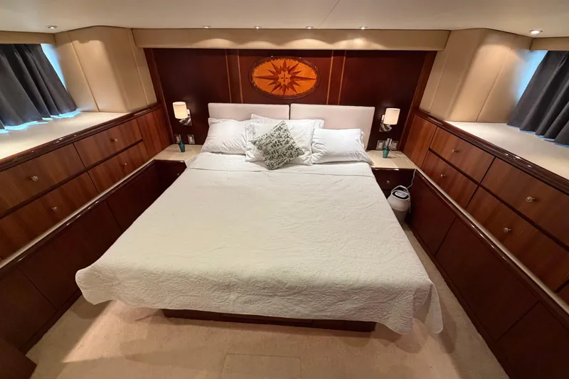  Yacht Photos Pics Luxurious bedroom in a 1991 Hatteras 70 Motor Yacht with elegant wood cabinetry.