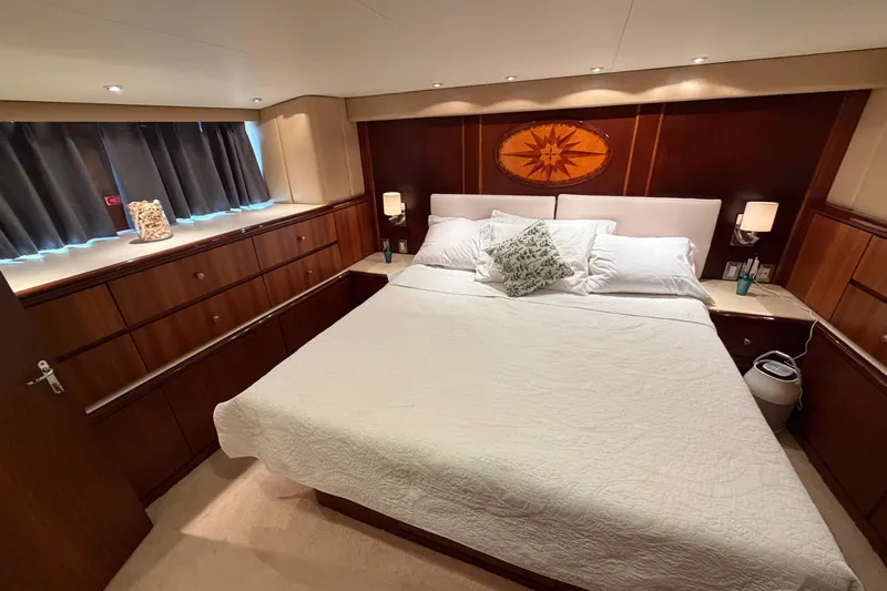  Yacht Photos Pics Luxurious bedroom interior of 1991 Hatteras 70 Motor Yacht with elegant wood paneling.