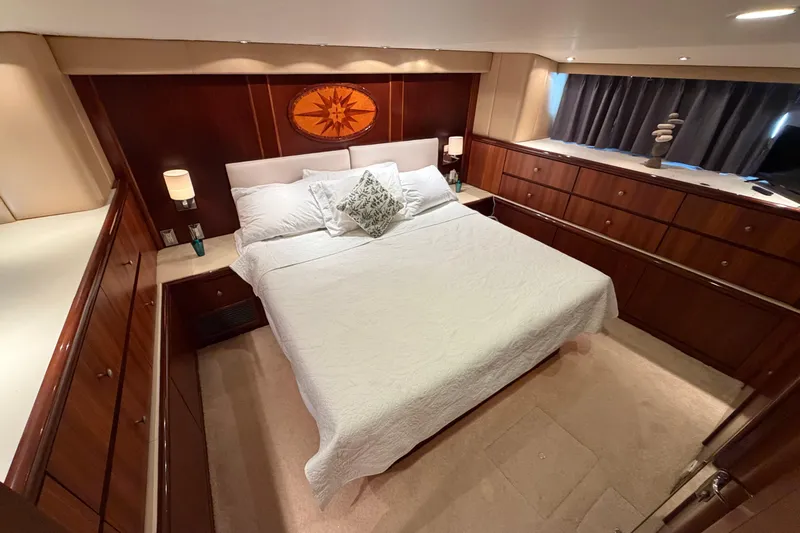  Yacht Photos Pics Luxurious bedroom interior of 1991 Hatteras 70 Motor Yacht with elegant wood paneling.