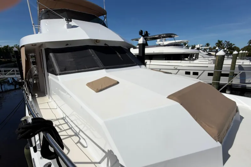  Yacht Photos Pics 1991 Hatteras 70 Motor Yacht docked, showcasing sleek design and spacious deck.