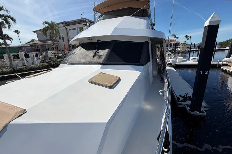  Yacht Photos Pics 1991 Hatteras 70 Motor Yacht docked at marina, sunny day, palm trees in background.