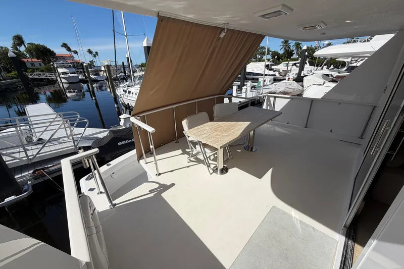  Yacht Photos Pics 1991 Hatteras 70 Motor Yacht aft deck with table, chairs, and marina view.
