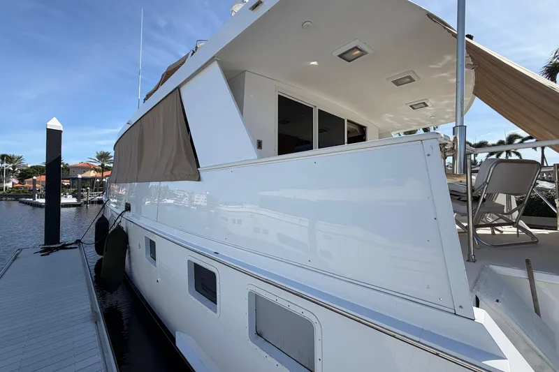  Yacht Photos Pics 1991 Hatteras 70 Motor Yacht docked, showcasing sleek design and spacious deck area.