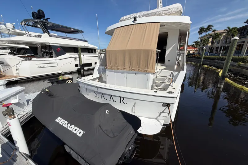  Yacht Photos Pics 1991 Hatteras 70 Motor Yacht docked with covered Sea-Doo, sunny marina setting.