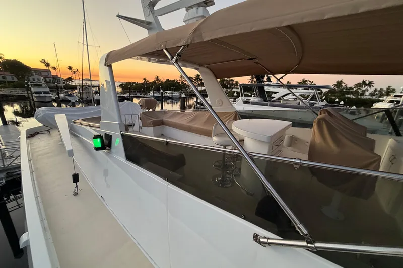  Yacht Photos Pics 1991 Hatteras 70 Motor Yacht docked at sunset, featuring covered seating and sleek design.