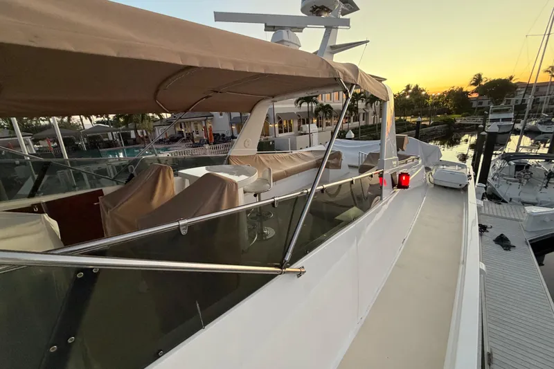  Yacht Photos Pics 1991 Hatteras 70 Motor Yacht docked at sunset, featuring covered seating and sleek design.