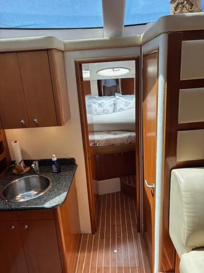  Yacht Photos Pics 2006 Carver 43 Motor Yacht interior with wood cabinetry, sink, and cozy bedroom.