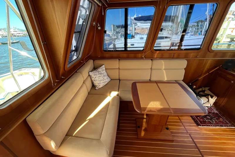 Sachem Yacht Photos Pics Interior of 2006 Sabre 36 Flybridge Sedan with beige seating and wooden table.