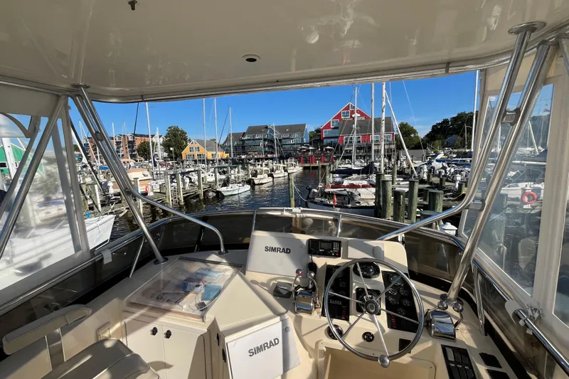 Sachem Yacht Photos Pics 2006 Sabre 36 Flybridge Sedan helm view overlooking marina with colorful buildings and boats.
