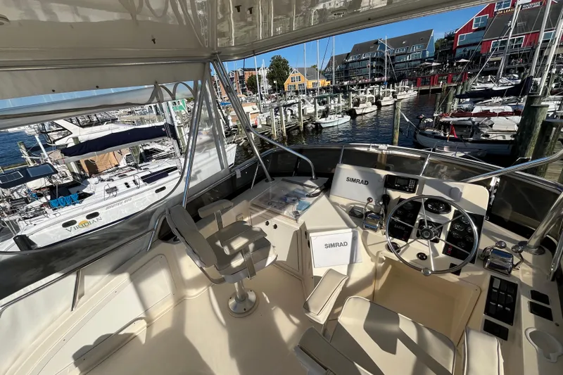 Sachem Yacht Photos Pics 2006 Sabre 36 Flybridge Sedan helm with marina view, featuring Simrad navigation equipment.