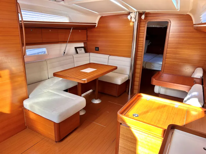 4770jg Yacht Photos Pics Interior of 2015 Dufour 410 GL yacht with wooden finish and cozy seating area.