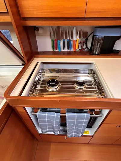 4770jg Yacht Photos Pics Dufour 410 GL 2015 yacht kitchen with stove, knives, and wooden cabinetry.