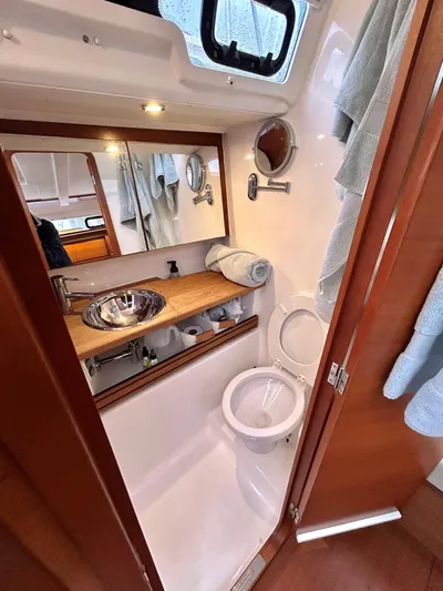 4770jg Yacht Photos Pics Compact bathroom in 2015 Dufour 410 GL yacht with sink, toilet, and mirror.