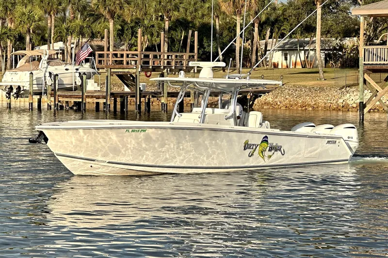  Yacht Photos Pics 2015 Jupiter 38 FS boat on calm water near a dock with palm trees.