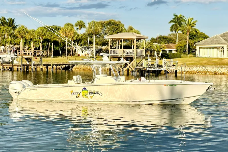  Yacht Photos Pics 2015 Jupiter 38 FS boat on calm water near a dock, surrounded by palm trees.
