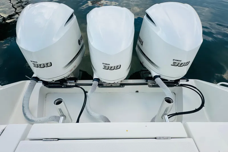  Yacht Photos Pics Triple Yamaha 300 engines on a 2015 Jupiter 38 FS boat, docked on calm water.