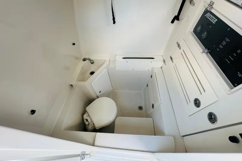  Yacht Photos Pics 2015 Jupiter 38 FS boat interior with compact bathroom and control panel.
