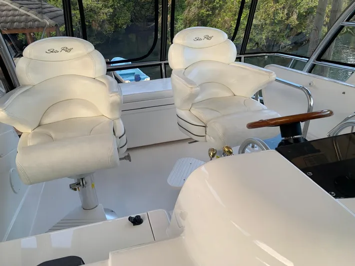  Yacht Photos Pics Interior of 2006 Sea Ray 52 Sedan Bridge with white captain chairs and steering wheel.