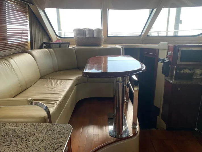  Yacht Photos Pics Interior of 2006 Sea Ray 52 Sedan Bridge yacht with leather seating and wooden table.